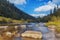 River in mountains with rocks, yellow grass on riverside. Autumn mountains landscape, sky, clouds. Idea for outdoor activities,