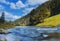 River in mountains with rocks, yellow grass on riverside. Autumn mountains landscape, sky, clouds. Idea for outdoor activities, tr