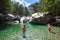 River in a natural landscape, some children inside water.