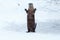 River otter standing and waving on the ice