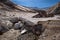 River passing under the thick icy layer of the glacier inside Mutnovsky Volcano crater