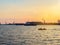 River port with ships at sunset. Busy traffic artery. Logistics and infrastructure. Loading and unloading of ships. Industry and