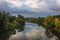 River with reflections of green trees under blue skies with fluf