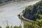 The river Rhine in western Germany flows between the hills covered with forest, visible river bend and traffic lights for ships.