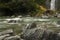 River with rocks, milky water, and waterfall