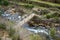 River runs hard under a fragile wooden bridge in Arouca, Portugal