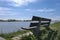 River shore and empty bench. Summer landscape of a river with calm water to relax near the riverside. Beautiful and tranquility