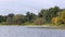 River shoreline with trees grasses and a boat