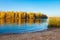 River side. Autumn nature landscape. Scenic riverside and yellow trees. Fall. River shore. Calm evening on river