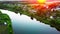 River at sunset in a city park with clouds reflecting in the water