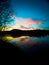 River at sunset with pink clouds. Dramatic sky with glowing pink clouds, symmetrical reflections in the water.