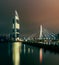 The river to the bridge and the high-rise and the city lights reflecting the water