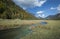 River to lake Mittersee during autumn, cloured trees and mountains in background, Bavaria Germany