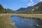 River to lake Mittersee during autumn, cloured trees and mountains in background, Bavaria Germany