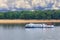 A river tram runs along the banks of the Dnipro against the backdrop of a deserted beach in anticipation of an impending