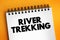 River trekking - mountain stream climbing is a form of hiking or outdoor adventure activity, text concept on notepad