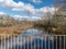 River view from the bridge, small river in early spring, blue sky and reflections in the water