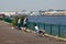 River view father and sons fishing over railings into a river with industrial landscape behind