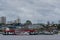 River view of a ferry refueling at a floating fuel station at the port of Manaus, with city skyscrapers visible in the background