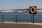 River view showing orange life bouy by railings as a public safety device.  Nobody visible