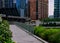 River walk ramp leading up to Wacker Drive with elevated `el` trains crossing over Chicago River.