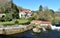 River with water mill and traditional pazo house with gardens, trees and blue sky. Ponte Maceira, Coruna, Spain.