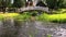 River water stream flow under white decorative bridge in park