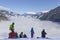 A river of white fog in the mountains and four people in front, snowboarders and skiers are preparing for the descent