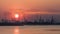 Riverbank with silhouettes of container terminal cranes during a sunset, Port of Antwerp, Belgium