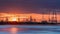 Riverbank with silhouettes of container terminal cranes during a sunset, Port of Antwerp, Belgium