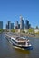 A riverboat in front of Frankfurt`s Skyline, seen from one of the bridges over the river.