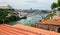 Riverboat sailing on the river Douro, with double-deck metal arch bridge