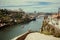 Riverboat sailing on the river Douro, with double-deck metal arch bridge