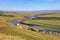 Rivers with village  aside and mountain faraway under blue sky