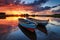 riverside landscape of colorful boats moored on a lakeshore at sunset