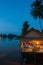Riverside restaurant near Mekong River at twilight. Coconut trees silhouette, Beautiful lighting, restaurant and sunset sky
