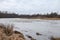 Riverside view of river flowing near countryside city with trees on winter