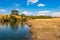 Riverside yellow grass countryside fields with bright blue sky at morning from flat angle