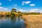 Riverside yellow grass countryside fields with bright blue sky at morning from flat angle