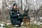 RIVNE, UKRAINE - DECEMBER 02, 2022. Police officer and homeless dog. Ukrainian female police officer takes care of stray dogs