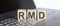 RMD abbreviation stands for written on a wooden cube on laptop