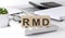 RMD required minimum distributions written on a wooden cube on keyboard with office tools