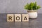 the ROA letters is written on wooden cubes on a gray background. close-up of wooden elements. In the black background is