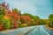 Road across New England countryside in foliage season, USA