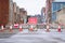 Road ahead closed sign with traffic cones and red barrier fence crossing