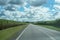 Road Amongst Cane Fields Under Cloudy Sky