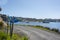 Road around coast or waterfront of Half Moon Bay with typically island posts with street numbers in white lettering on blue