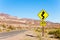 Road with arrow yellow sign in desert, California