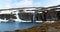 Road Aurlandsfjellet, Norway. Waterfall Flotvatnet In Spring Snowy Landscape. Scenic Route Road In Summer Norwegian