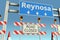 Road barricades near Reynosa city road sign. Coronavirus disease quarantine or lockdown in Mexico conceptual 3D